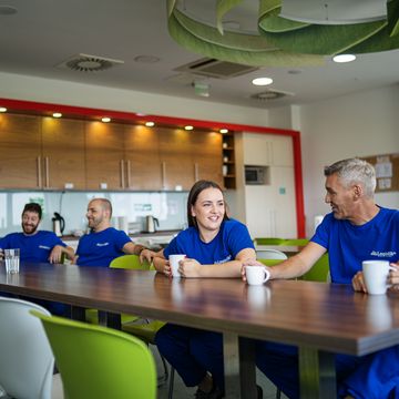 Koleginice i kolege u distributivnom centru u neformalnom razgovoru u kuhinji