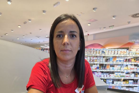 Snežana sedi za kasom u crvenoj dm uniformi za prodavce