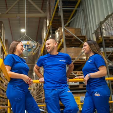 Koleginice i kolega u neformalnom razgovoru u dm magacinu