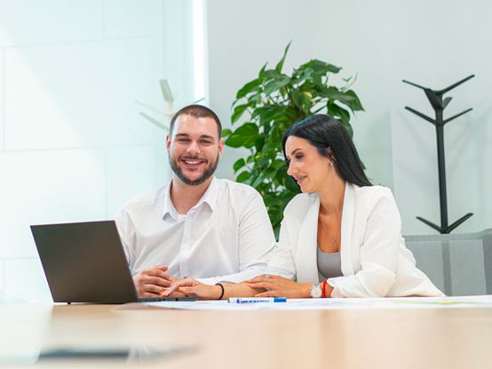 Koleginica i kolega rade zajedno na laptopu