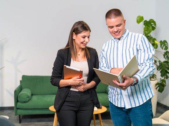 Koleginica i kolega zajedno čitaju