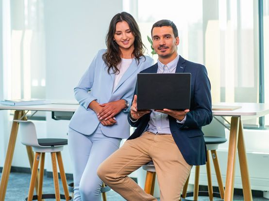 Koleginica i kolega zajedno rade na laptopu