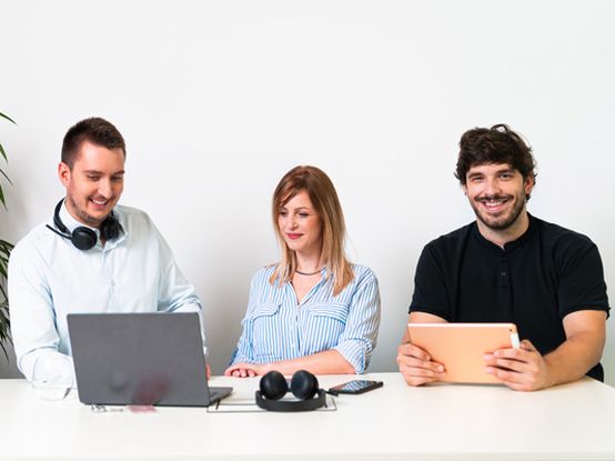 koleginica i kolege rade na laptopu i tabletu