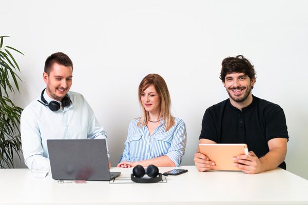 koleginica i kolege rade na laptopu i tabletu