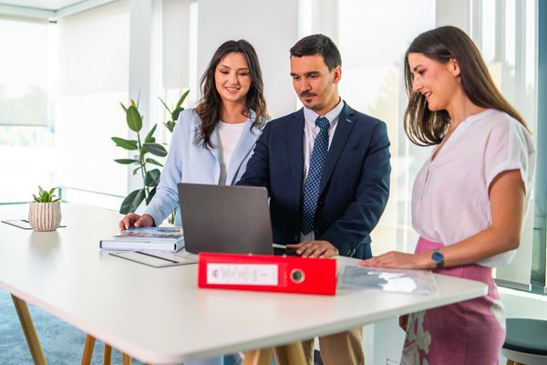 Dve koleginice i kolega rade zajedno na laptopu